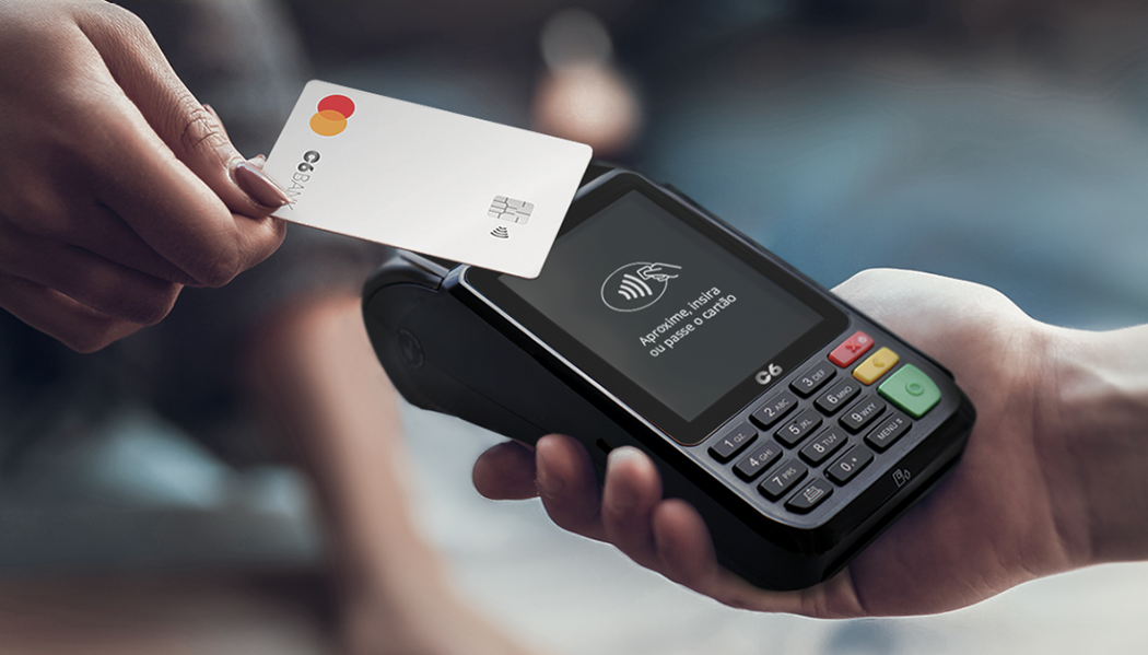 Foto de uma pessoa passando um cartão do C6 Bank numa maquininha C6 Pay Essencial