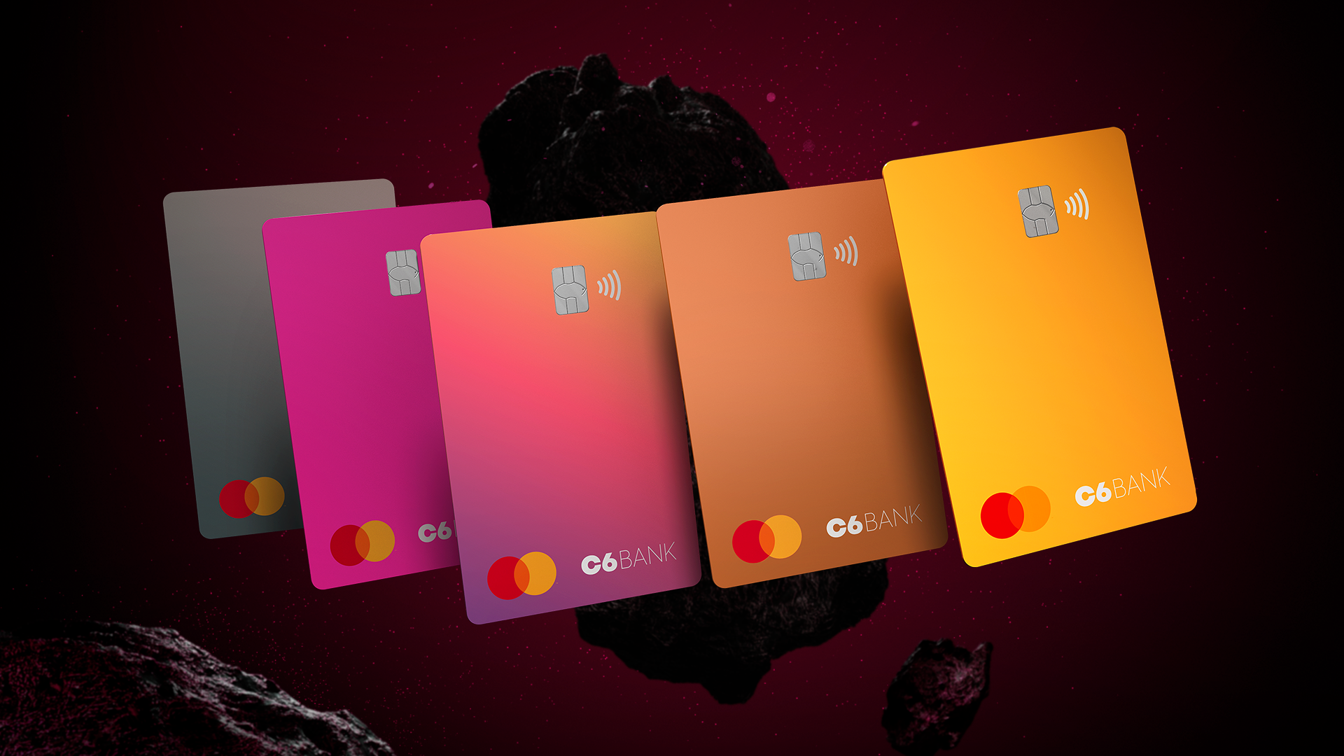 Imagem virtual dos cartões do C6 Bank com as cinco novas cores lado a lado em primeiro plano a frente de uma rocha espacial ao fundo